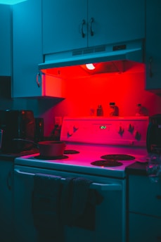 a kitchen with a stove top oven under a red light