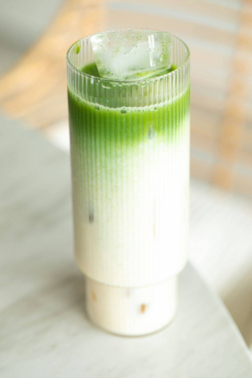 a green and white drink sitting on top of a table