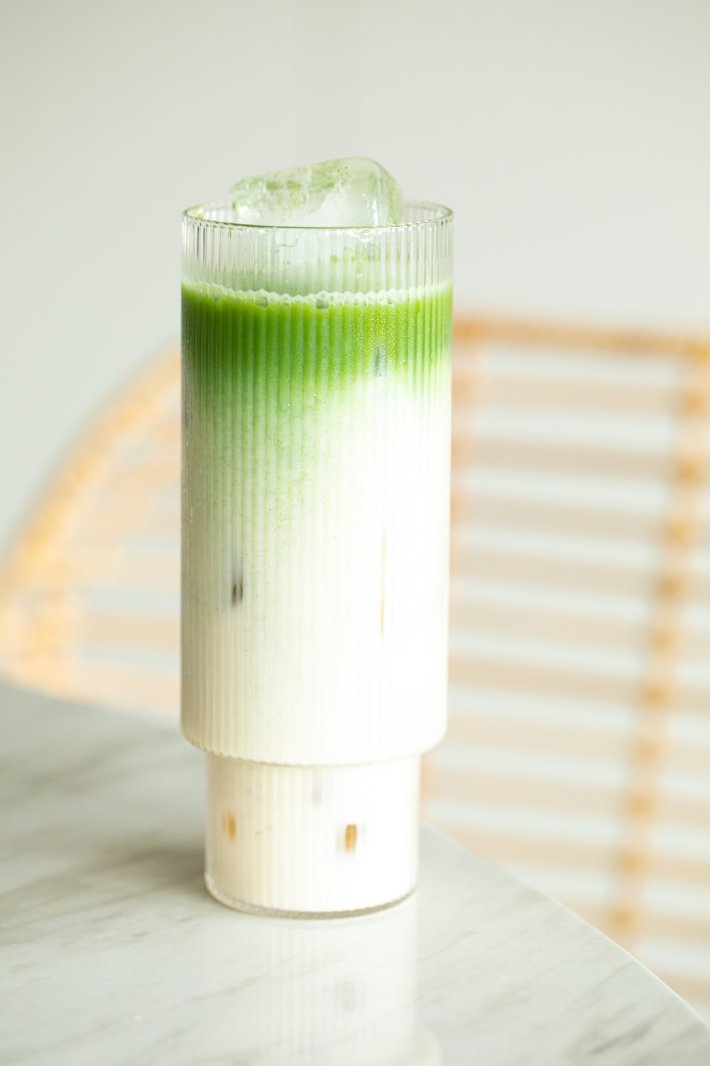 a green and white drink sitting on top of a table