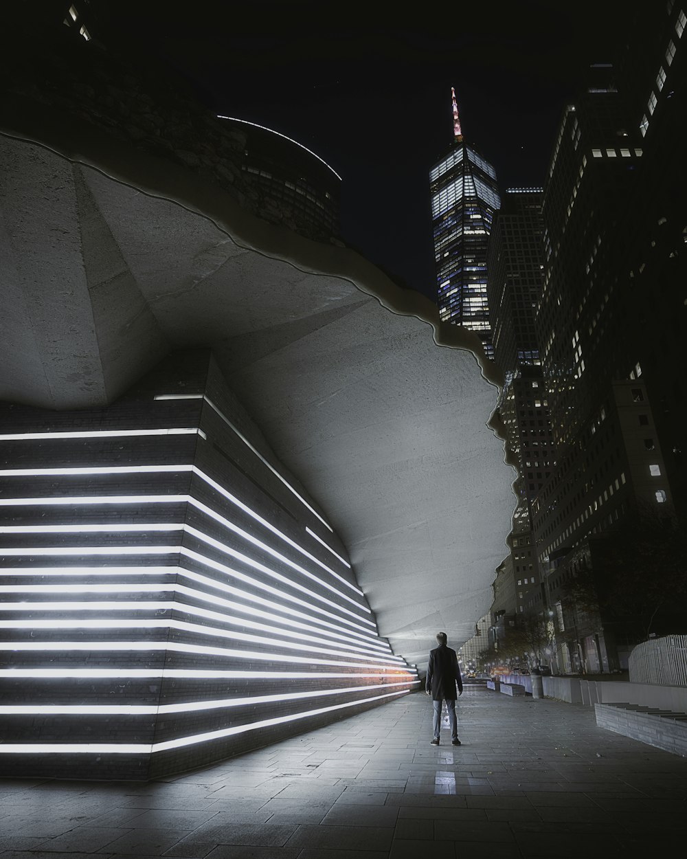 a man walking down a street next to tall buildings