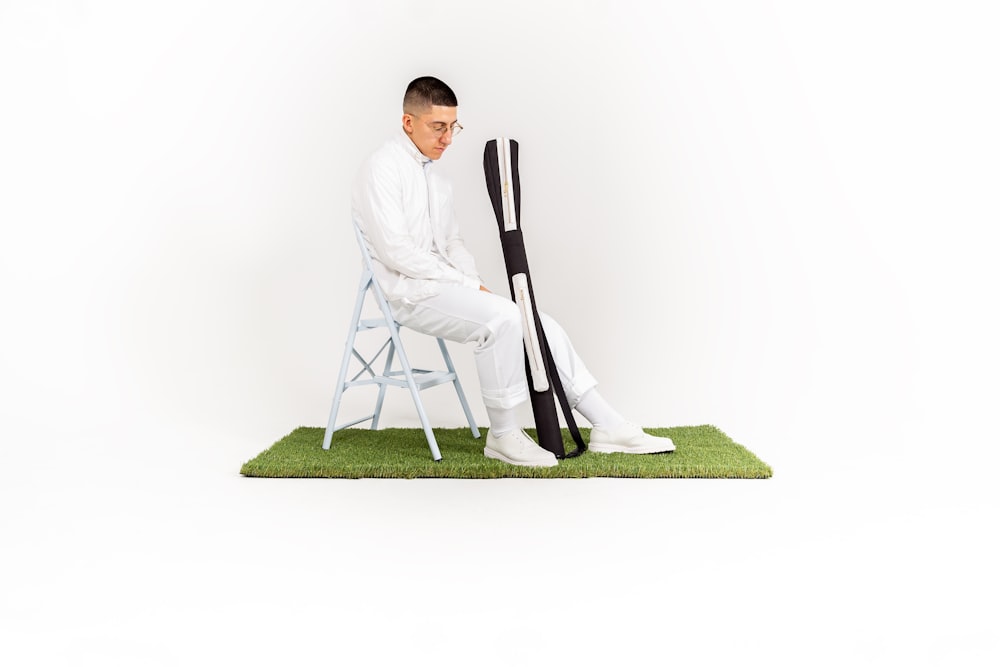 a man sitting on top of a chair next to a pair of skis