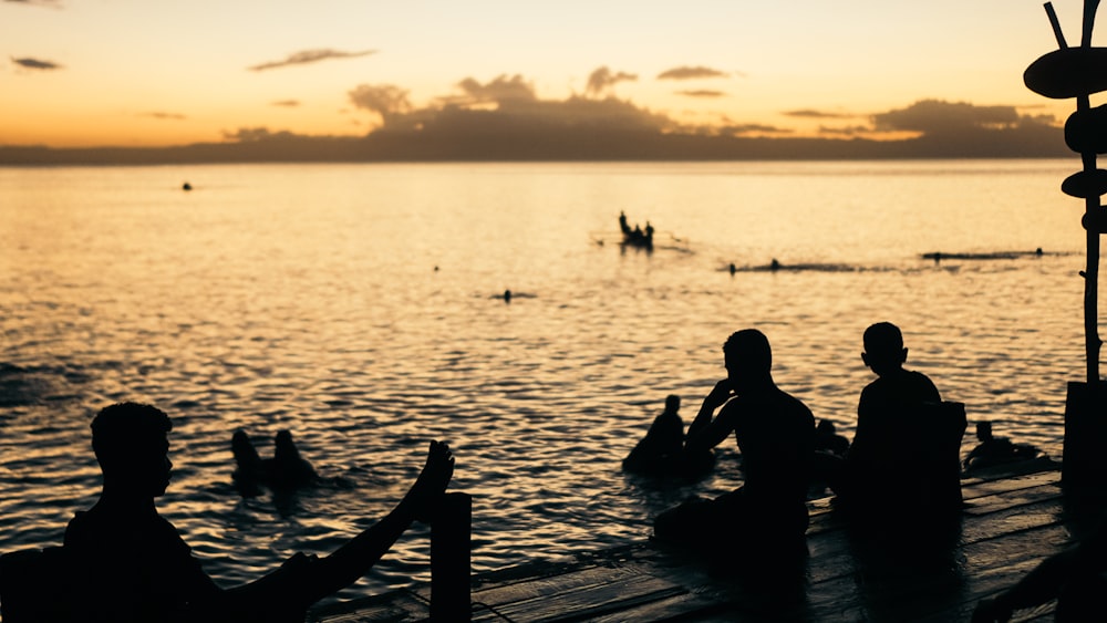 a group of people sitting on top of a pier