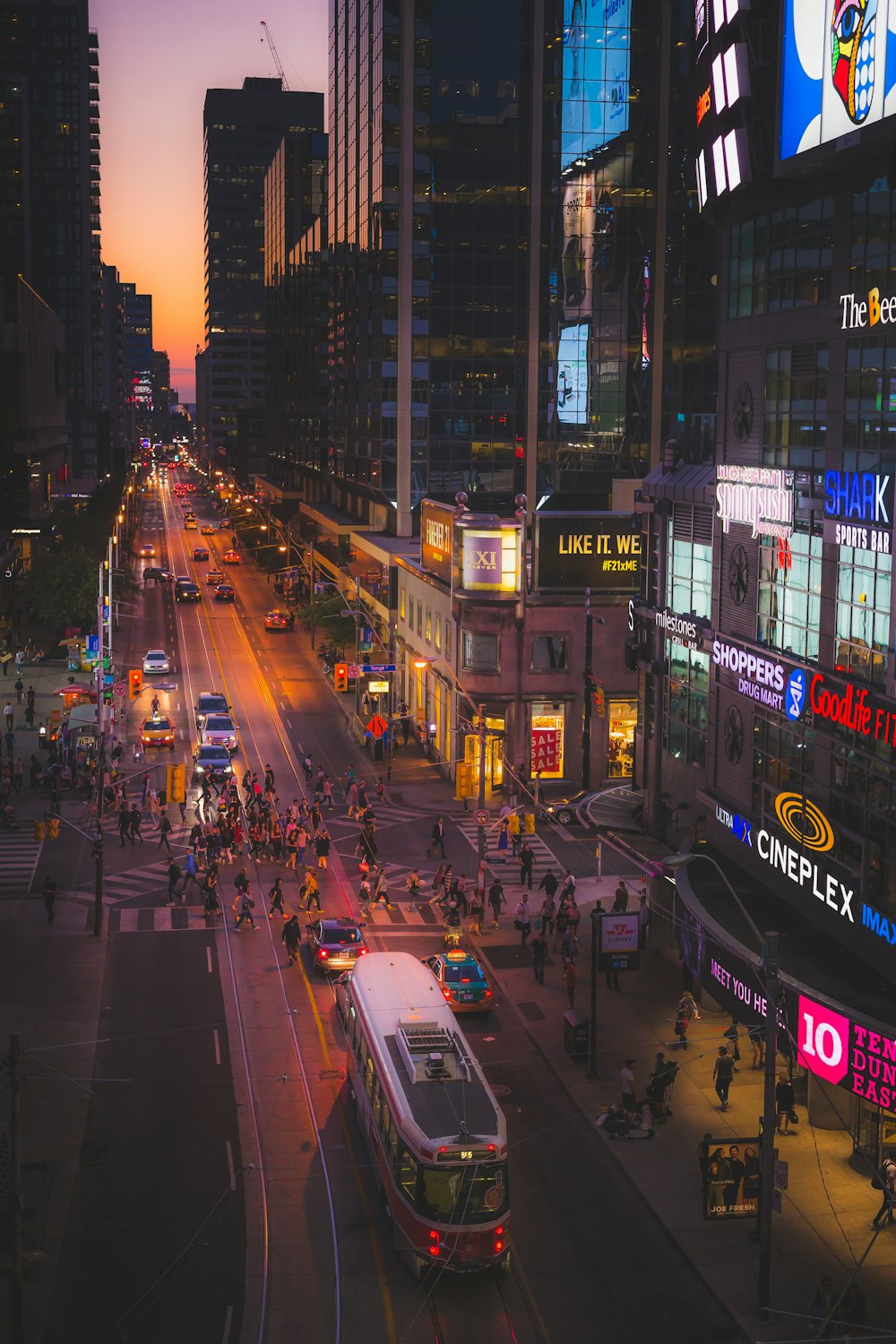 a busy city street at night with a bus on the road