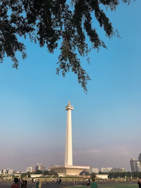 a group of people standing in front of a tall monument