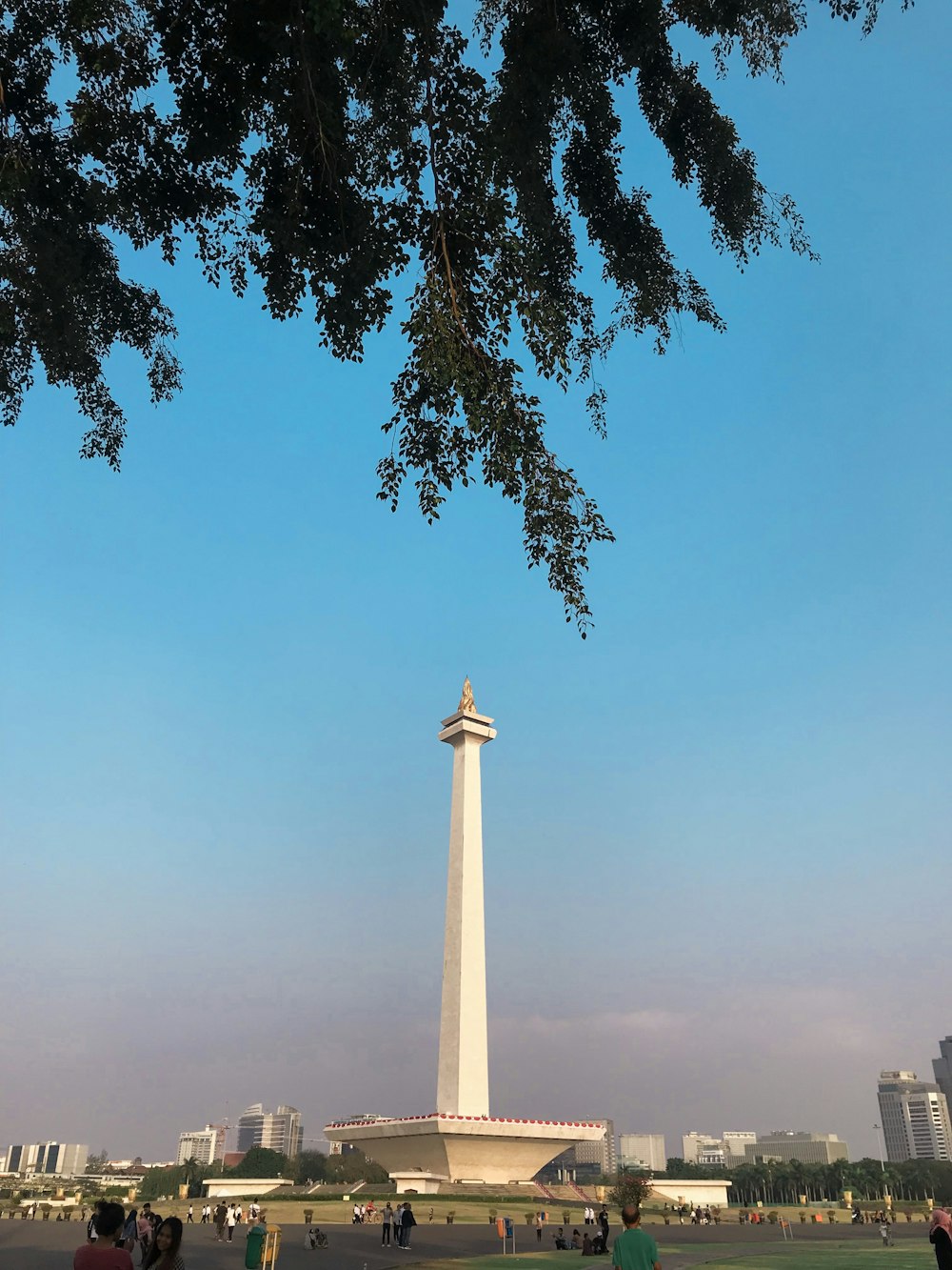 a group of people standing in front of a tall monument