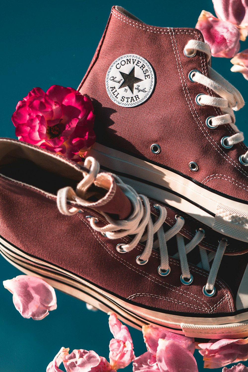 a pair of red sneakers with a flower on top of them