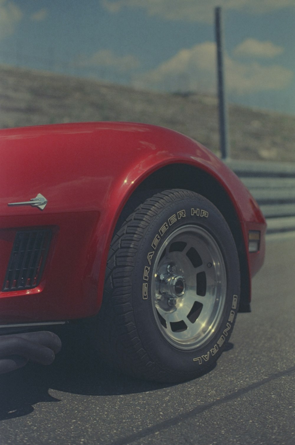 a close up of a red sports car on a road