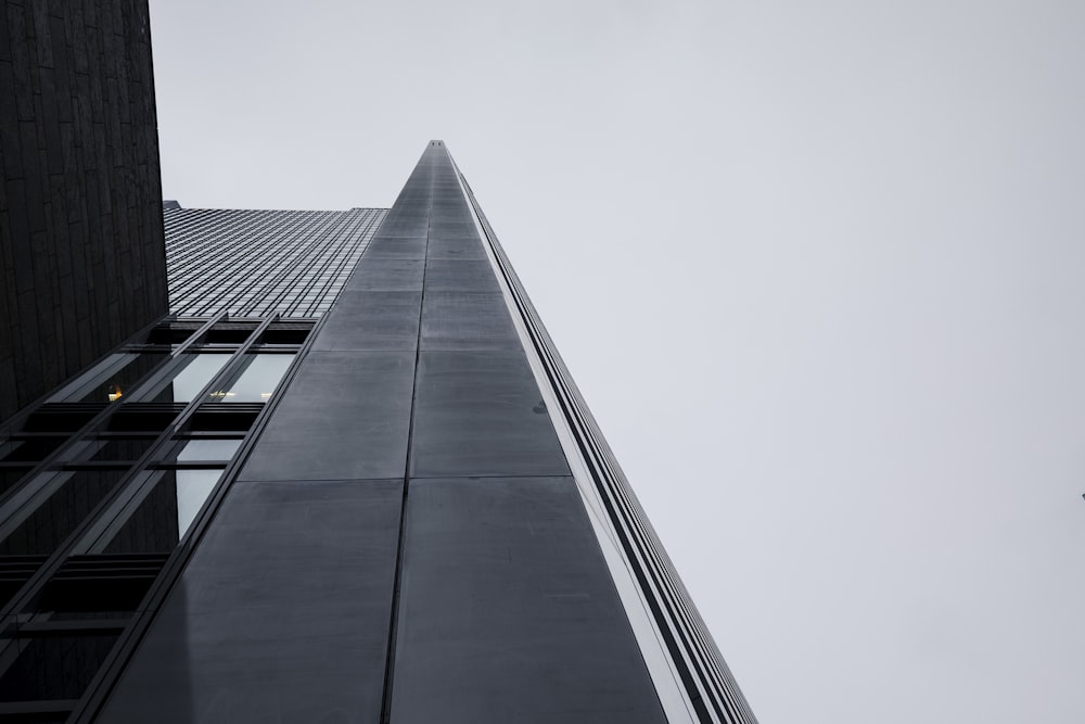 a tall building with a plane flying in the sky