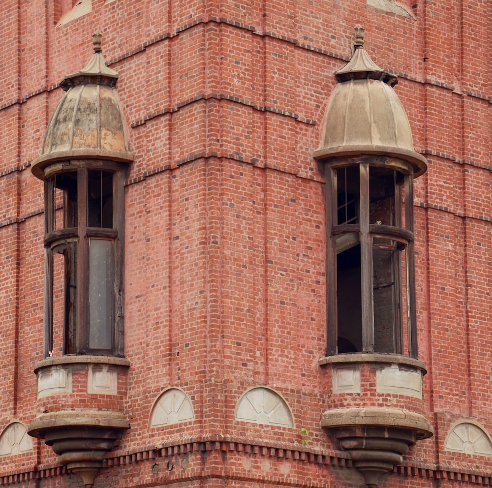 Un edificio in mattoni rossi con due finestre e un orologio