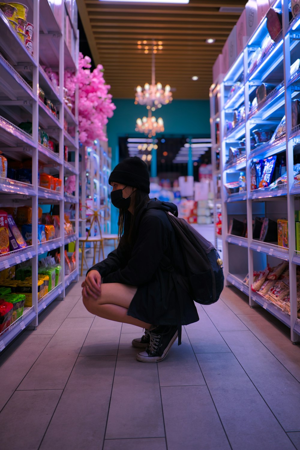 Eine Frau kniet in einem Ladengang