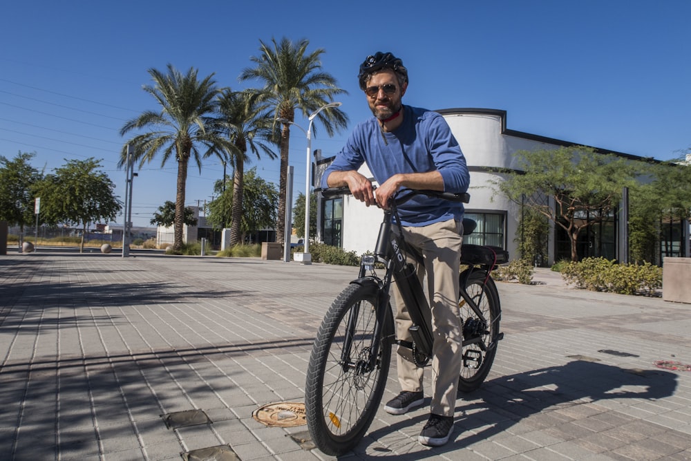 a man riding a bike down a sidewalk