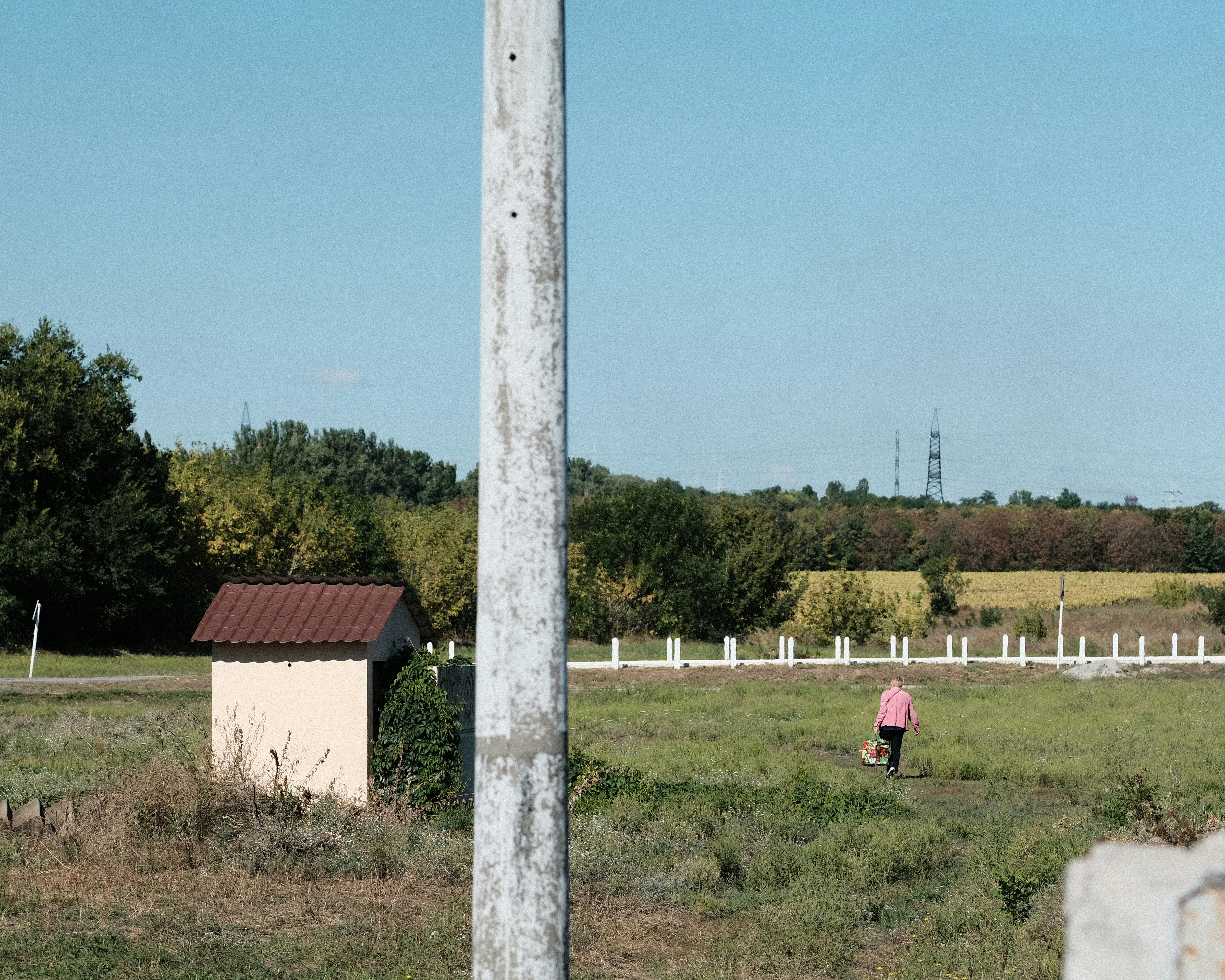 A person walking in a field near a building