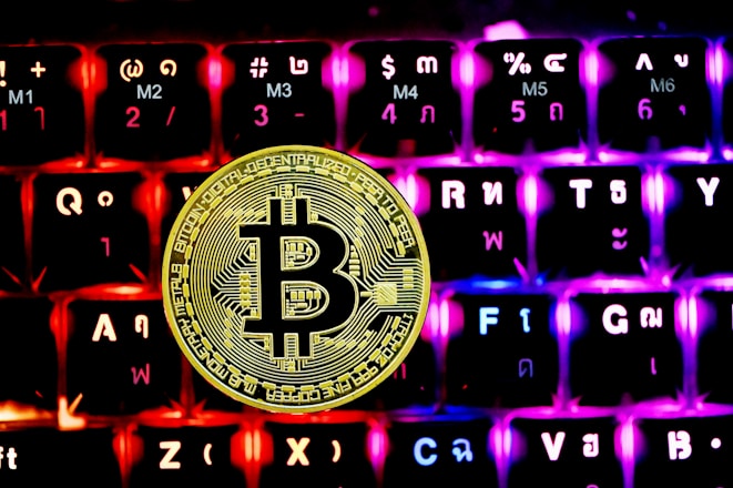 a bitcoin sitting on top of a computer keyboard