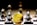 A gold Ethereum token is prominently placed on a black and white chessboard surrounded by several metallic chess pieces. The focus is on the Ethereum symbol on the coin, while the chess pieces appear slightly out of focus in the background. The lighting emphasizes the reflective surfaces of both the coin and the chess pieces.