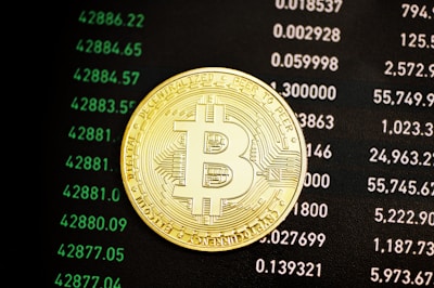 a bit coin sitting on top of a computer screen