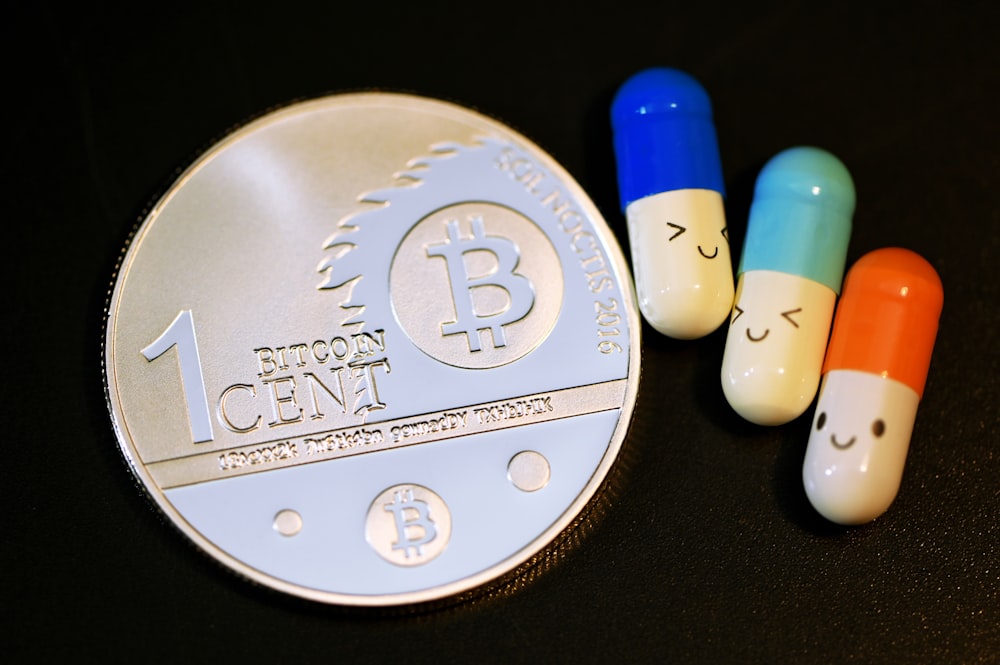 Drei Pillen sitzen auf einer Silbermünze