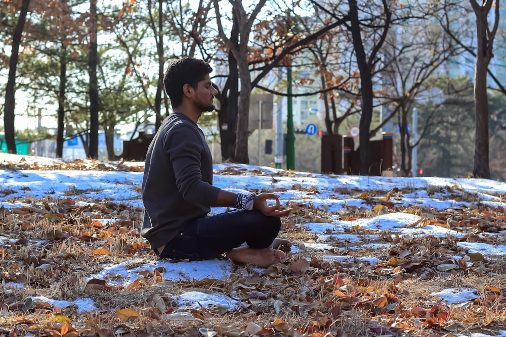 a man sitting on the ground in the snow