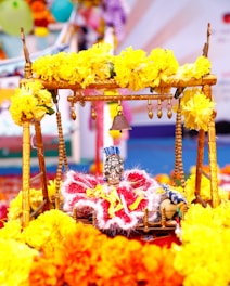 Close-up of intricate flower garlands draped over a wooden swing decorated for Mehendi.