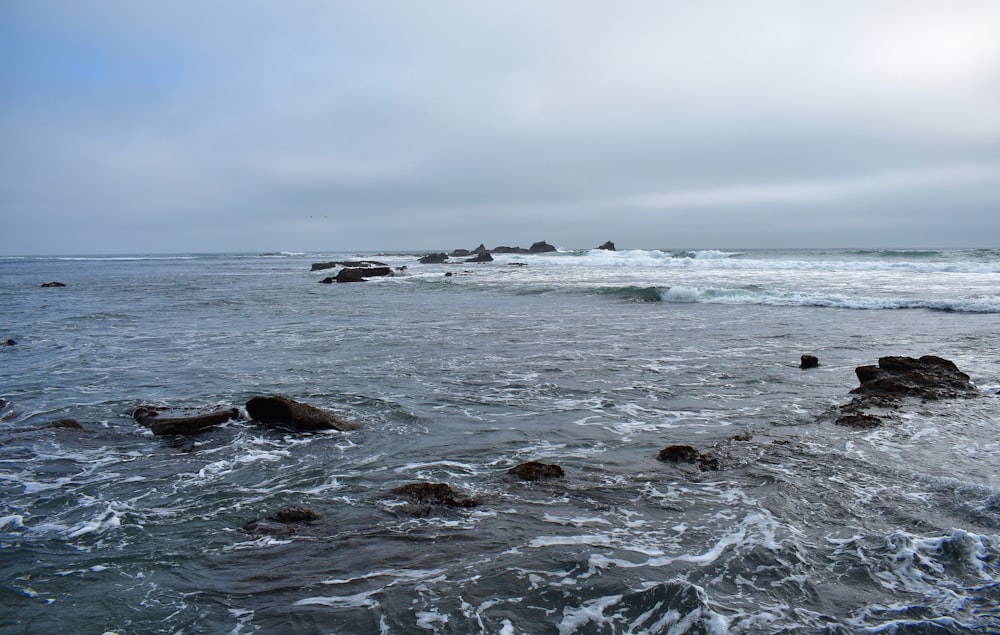 a body of water with rocks in the foreground