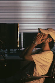 a man sitting in a chair with his head in his hands