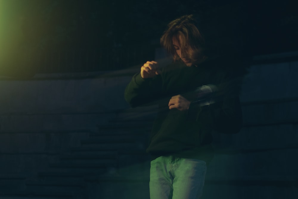 Un hombre parado frente a una luz verde