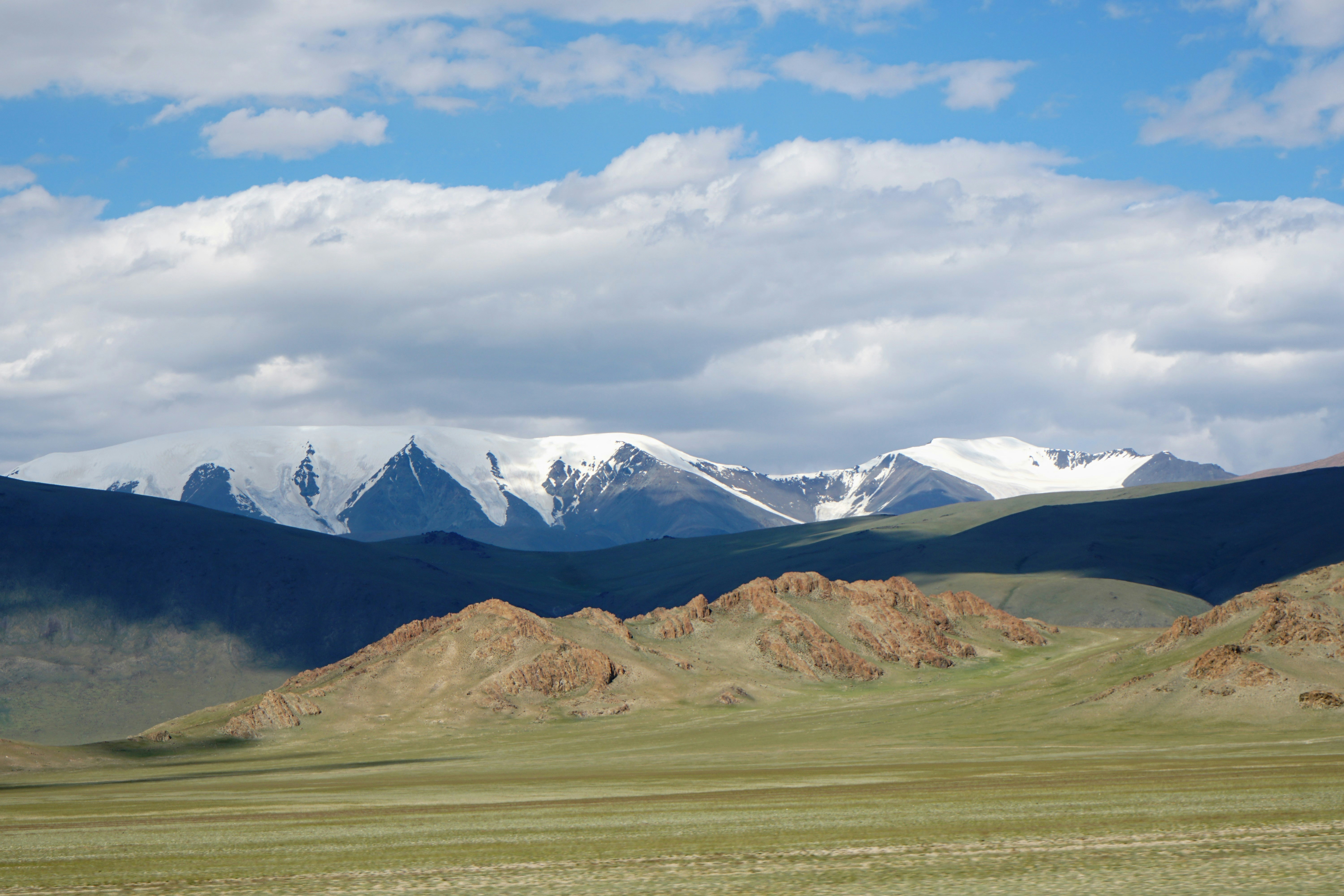 a mountain range with snow capped mountains in the distance