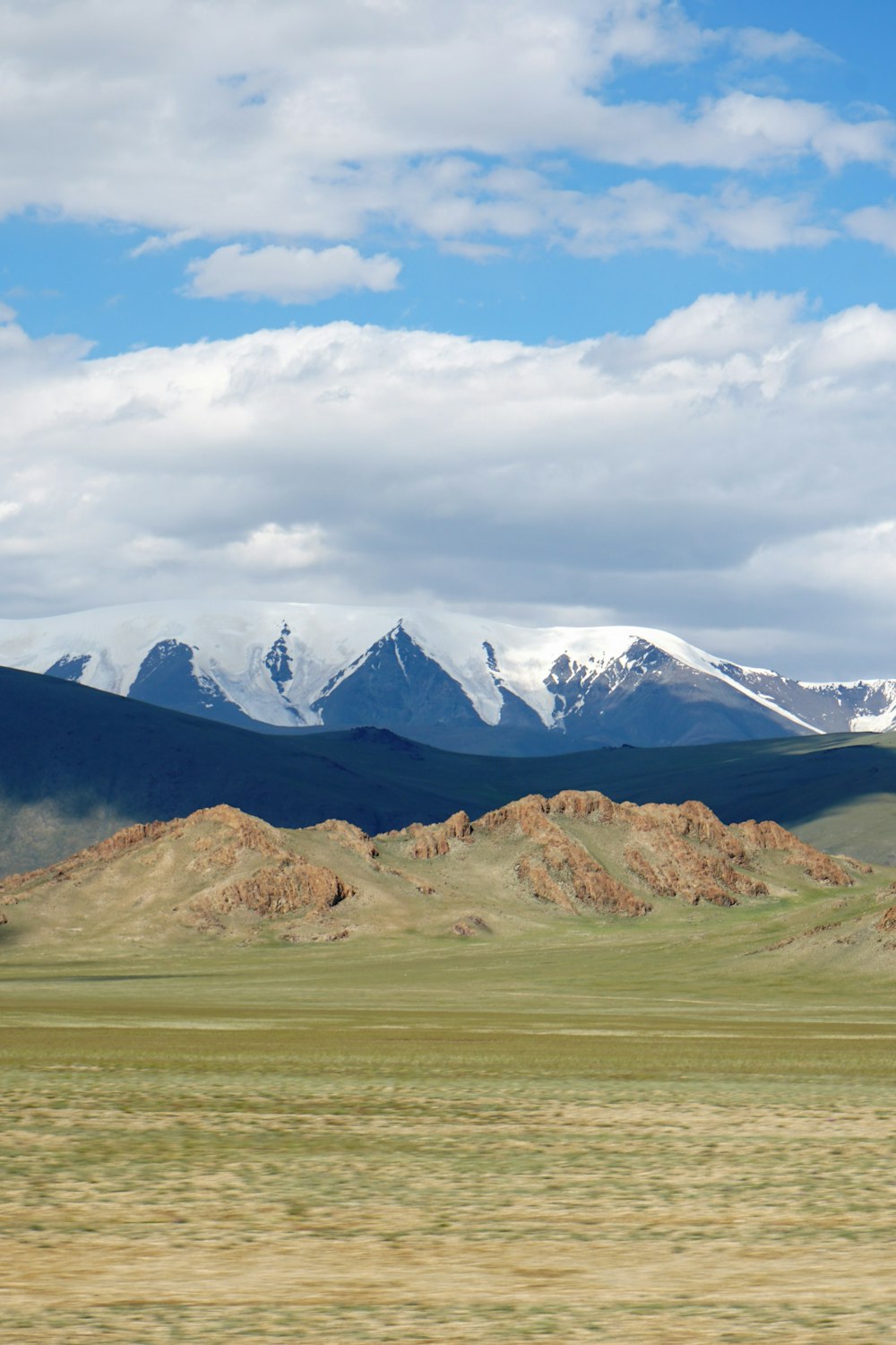 a mountain range with a few snow capped mountains in the distance