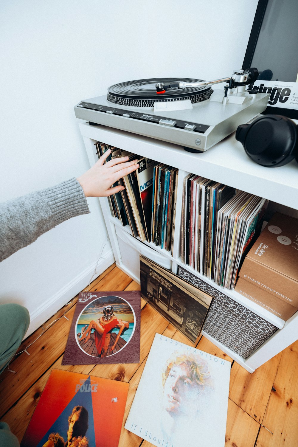 a person reaching for a record player in front of a record player