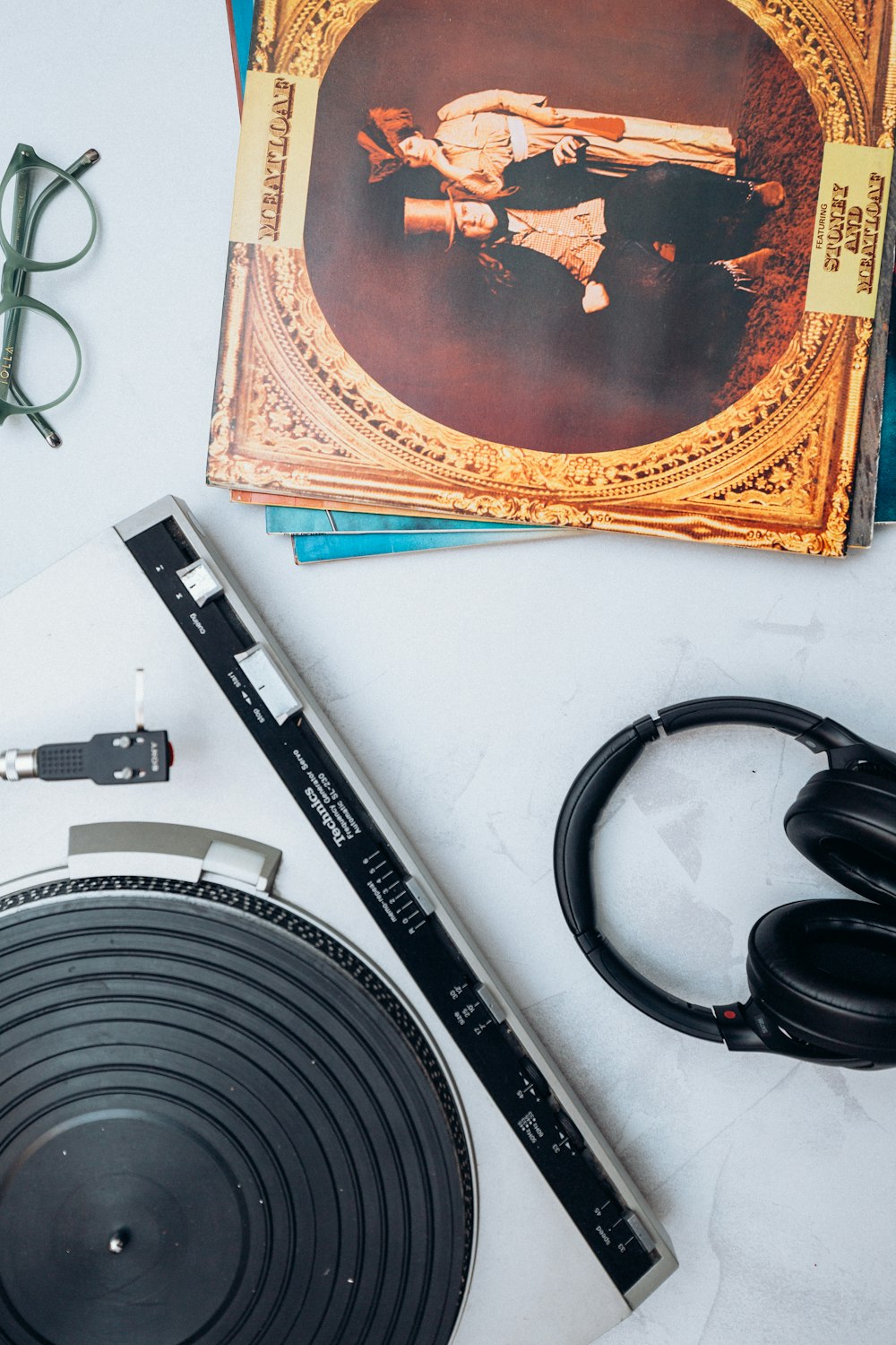 a record player, headphones, and a book on a table
