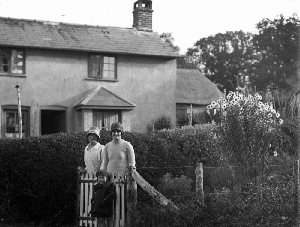 a couple of people standing next to a fence