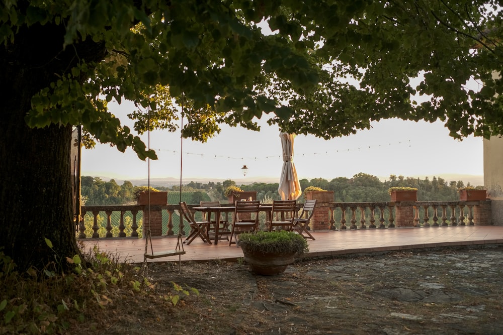 a patio with a table and chairs under a tree