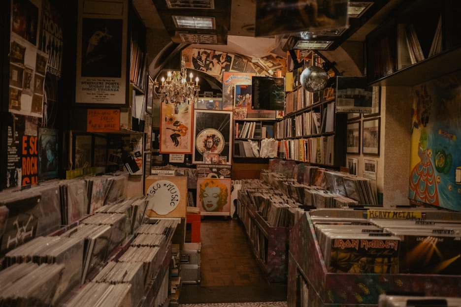 A cozy corner of the store with vinyl records displayed next to a small bar area with warm lighting.