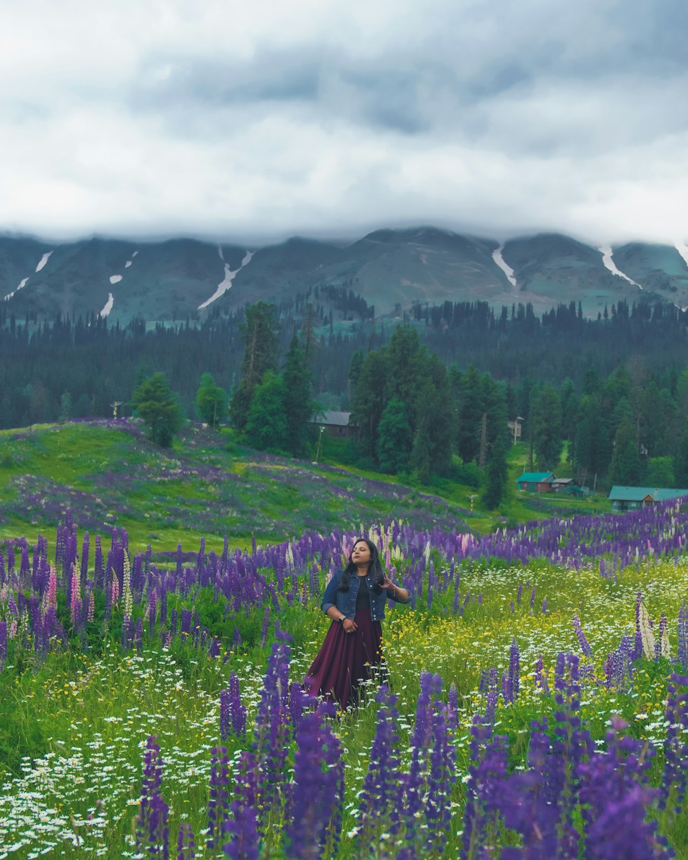 Una mujer de pie en un campo de flores púrpuras