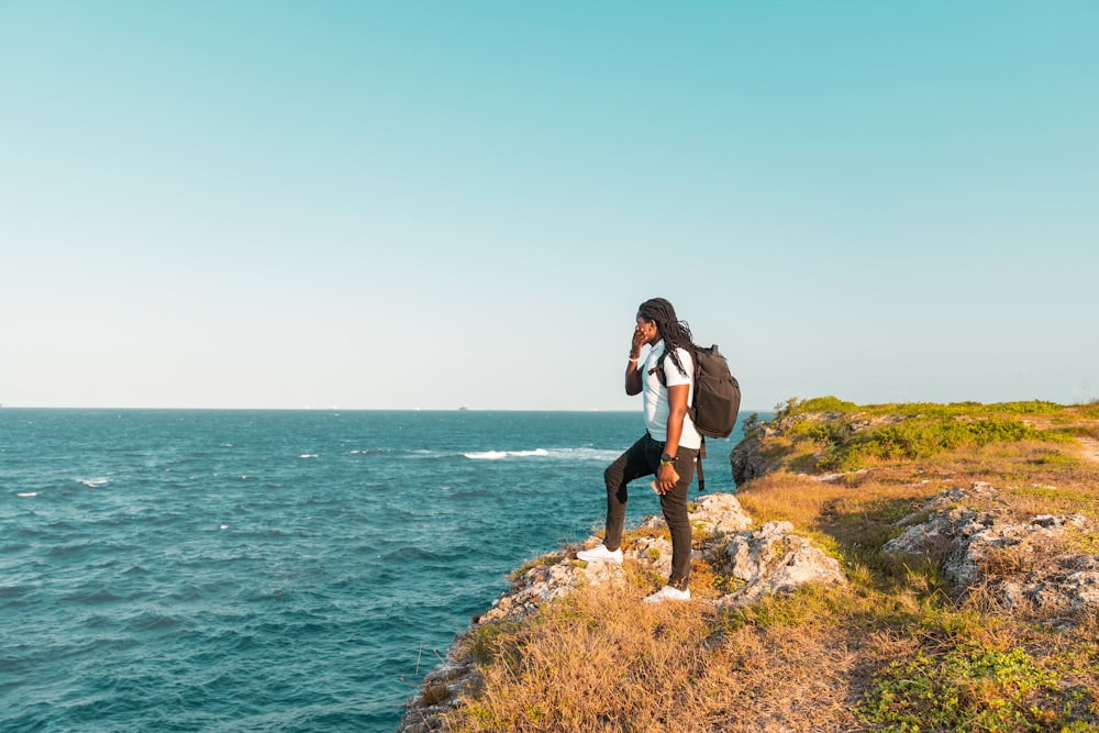 a person standing on a cliff overlooking the ocean