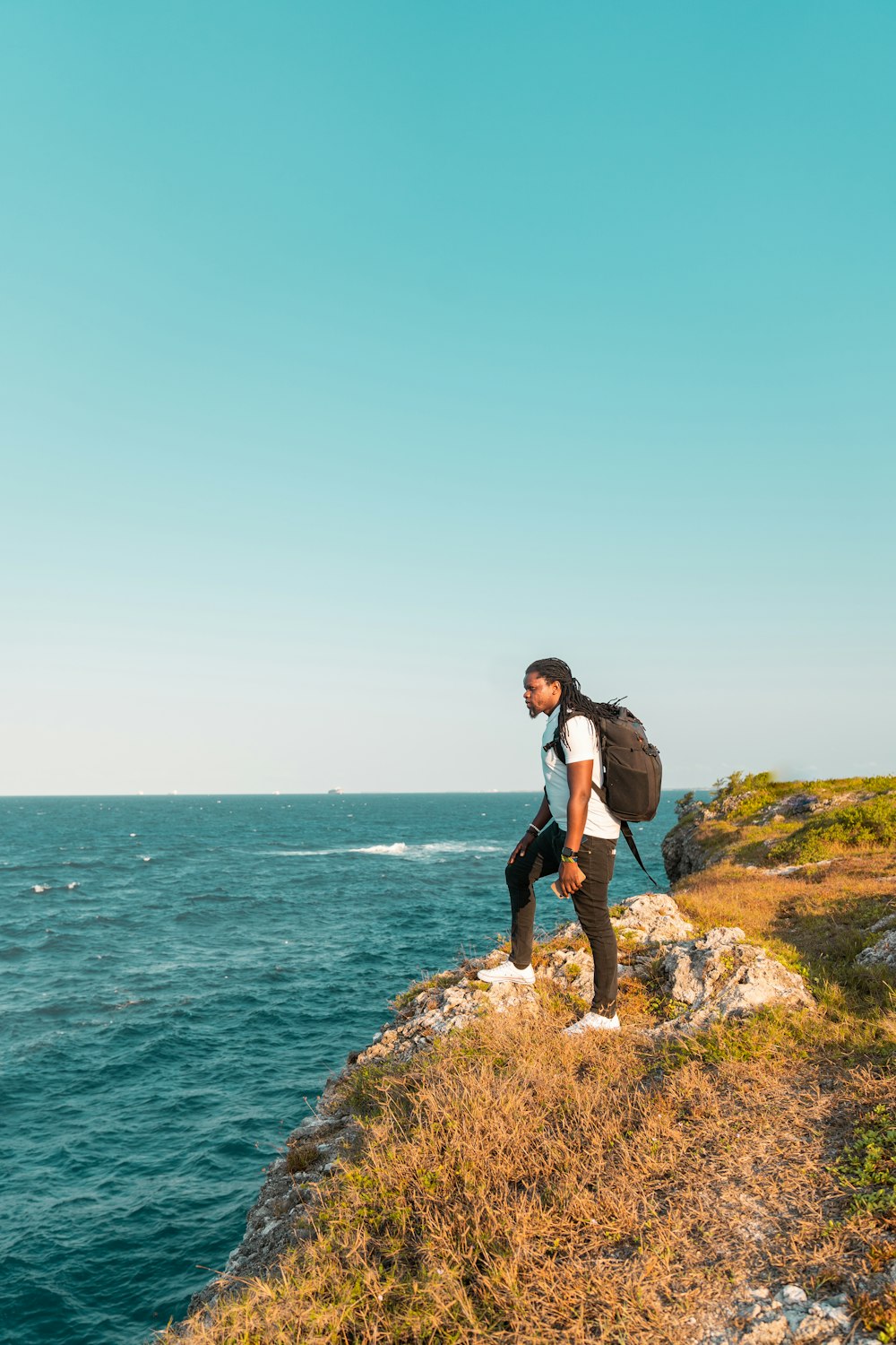 a person standing on a cliff overlooking the ocean