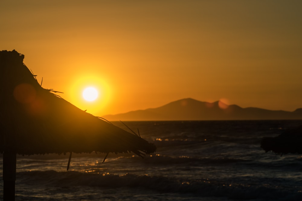 Le soleil se couche sur l’océan avec un parasol