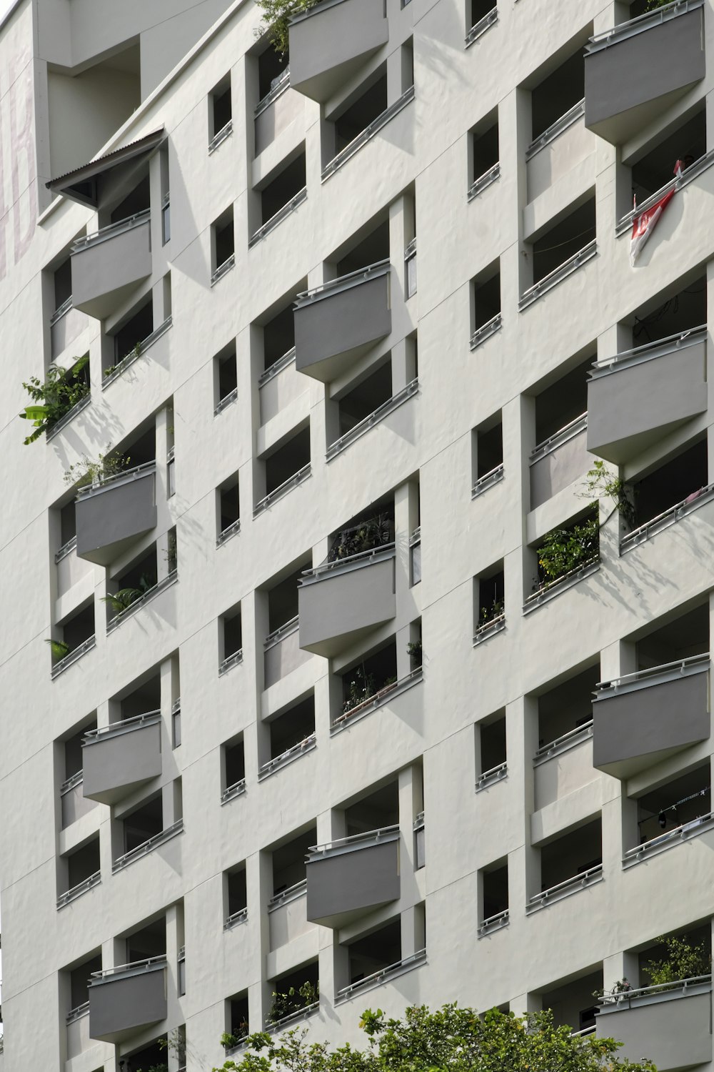 a tall building with balconies and plants on the balconies