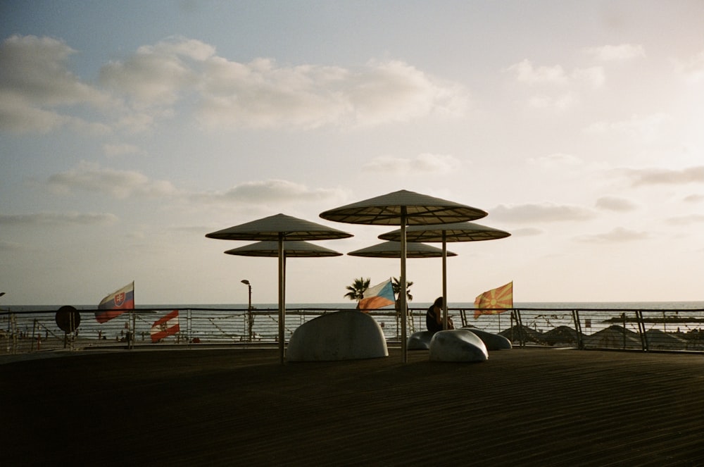 umbrellas and chairs on a wooden deck overlooking the ocean