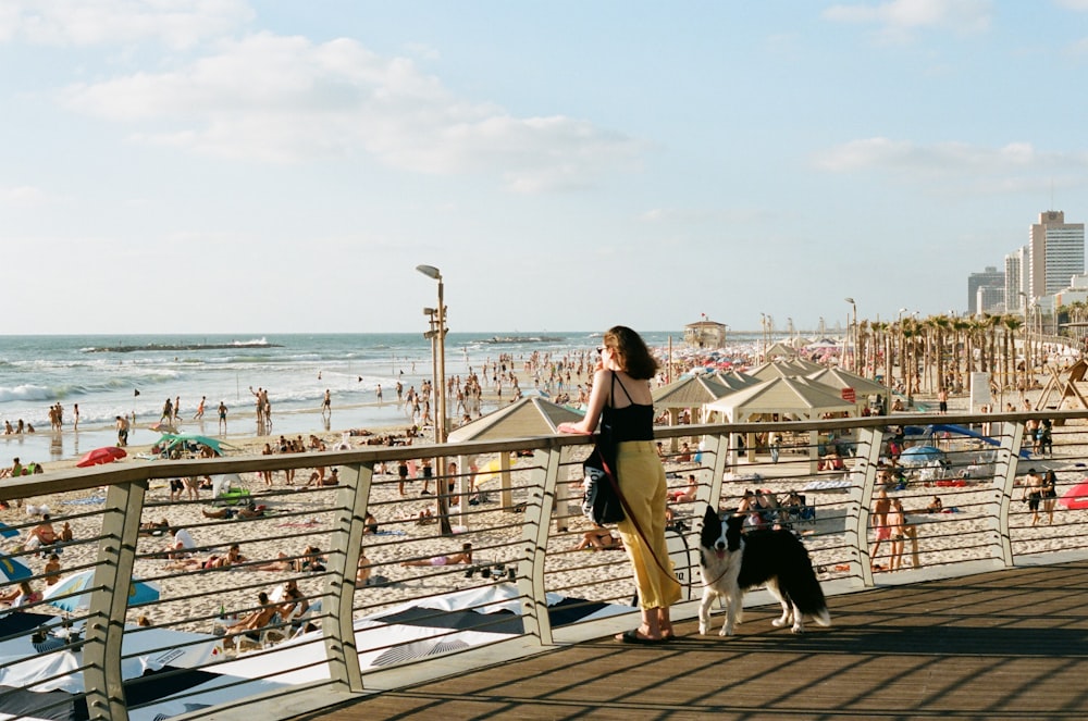 a woman standing on a boardwalk next to a dog