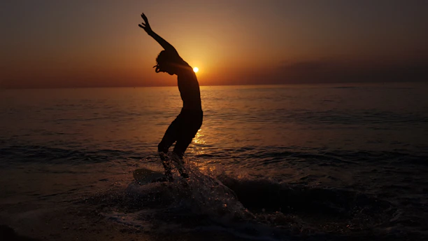 a person standing on a skimboard in the water