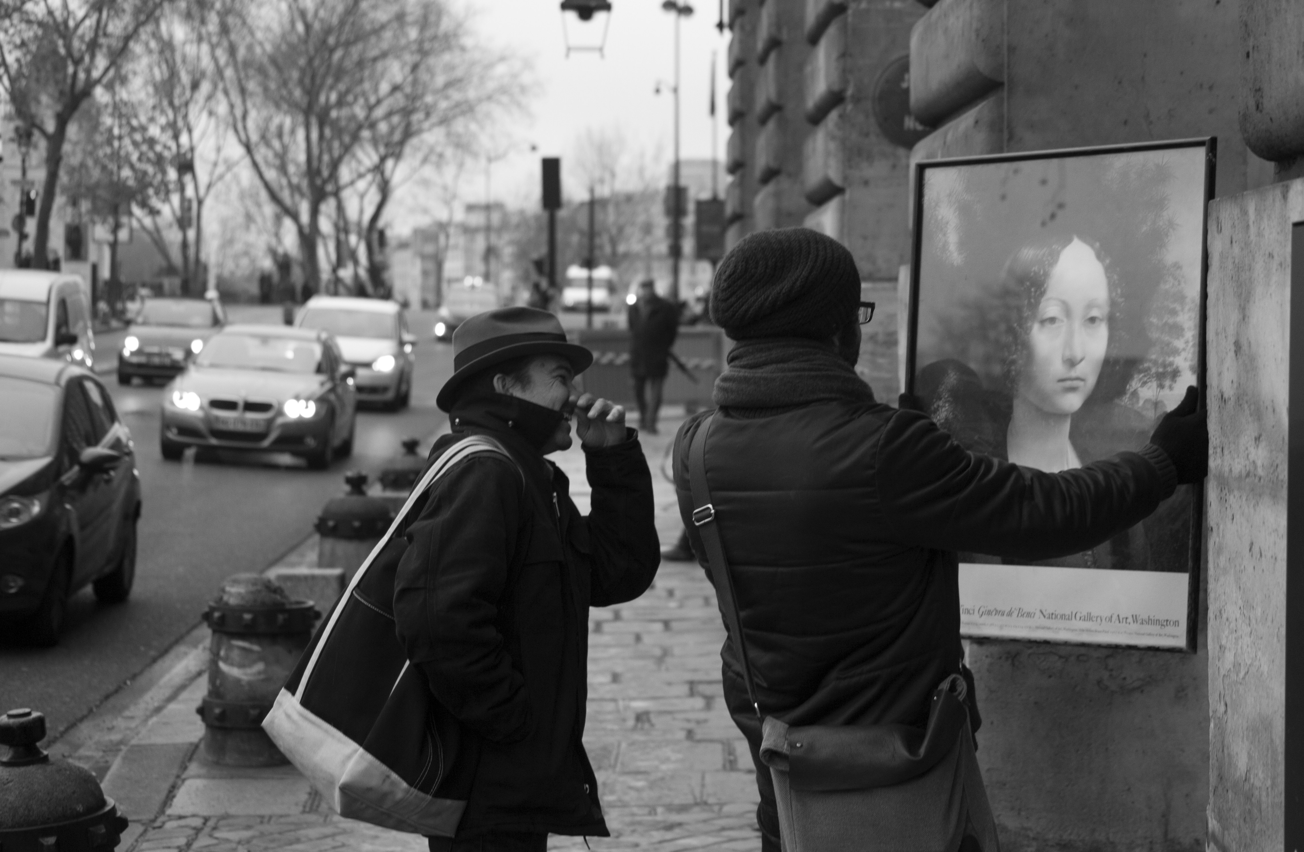 a man and a woman standing next to each other on a sidewalk