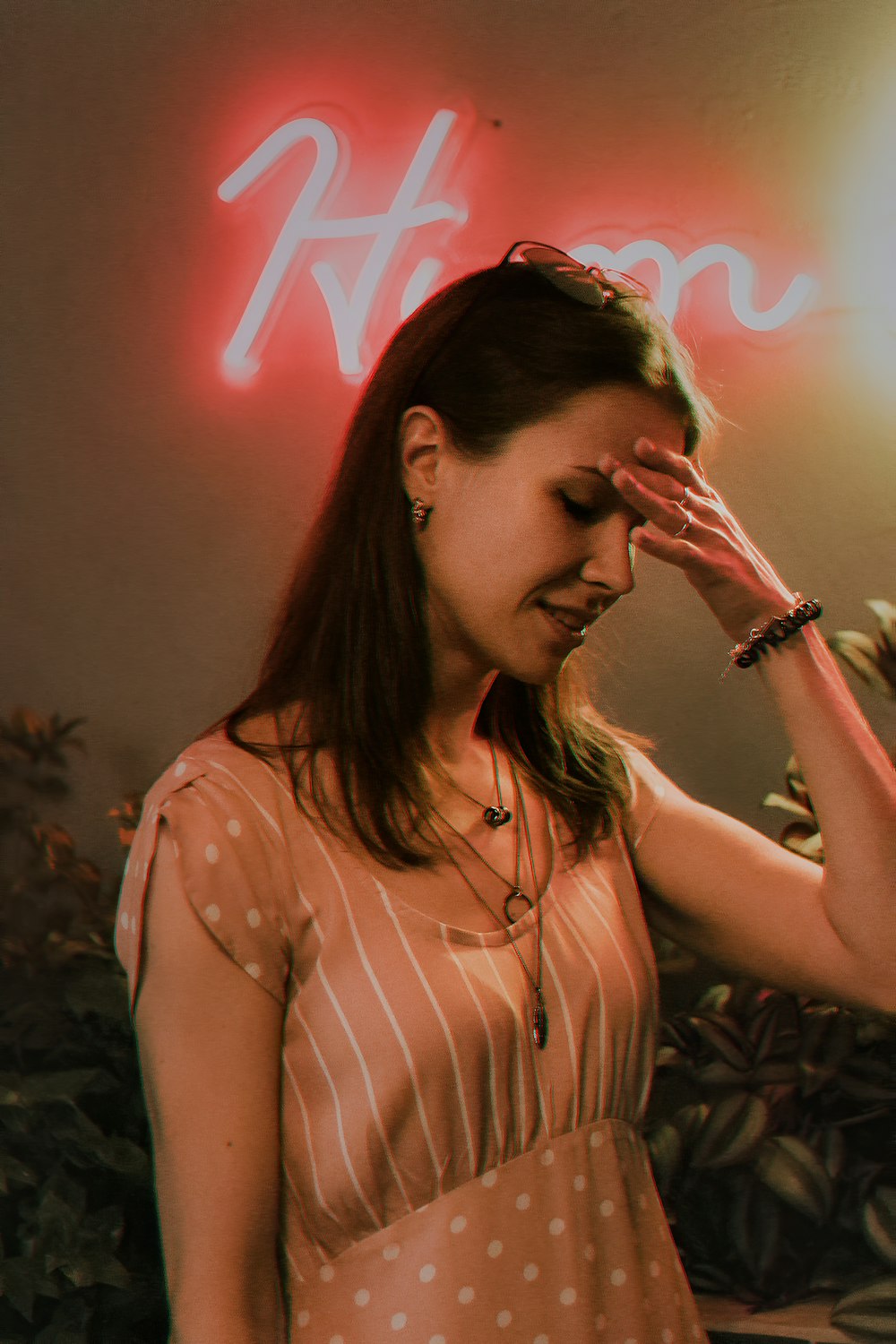 a woman standing in front of a neon sign