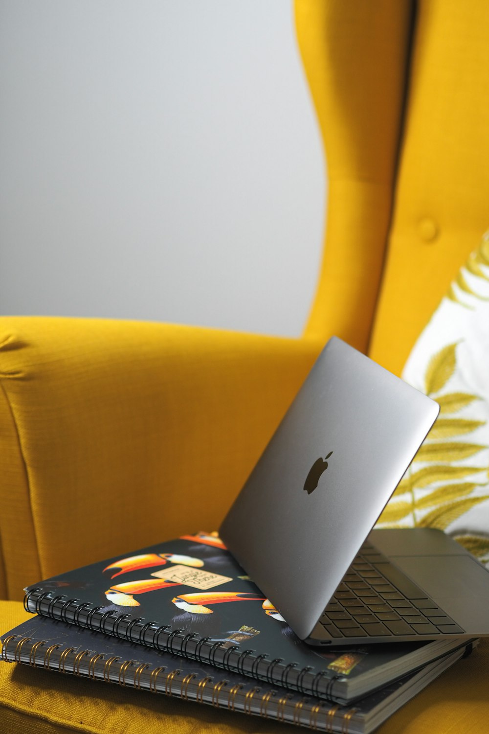 a laptop computer sitting on top of a yellow chair
