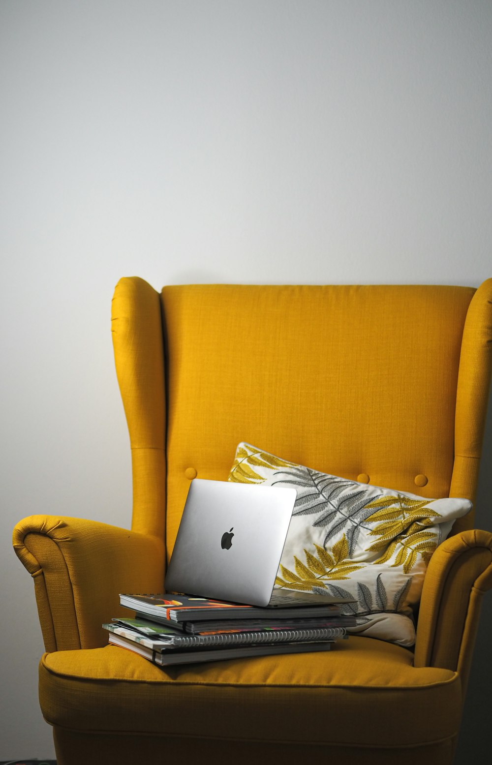 a yellow chair with a laptop on top of it