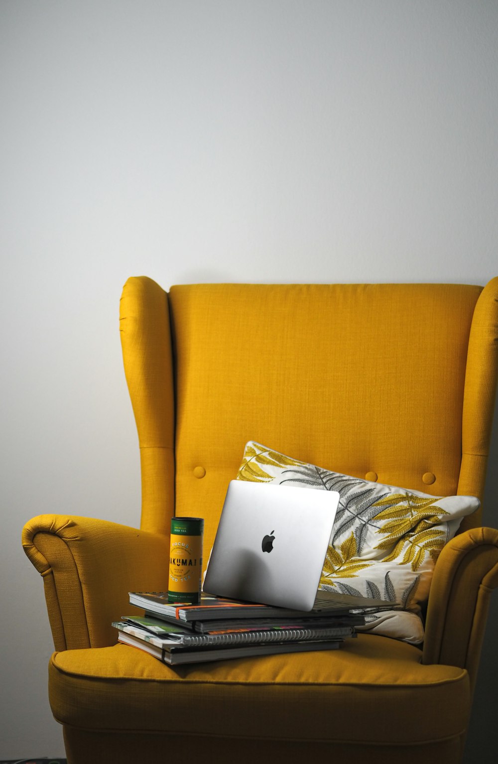 a laptop computer sitting on top of a yellow chair