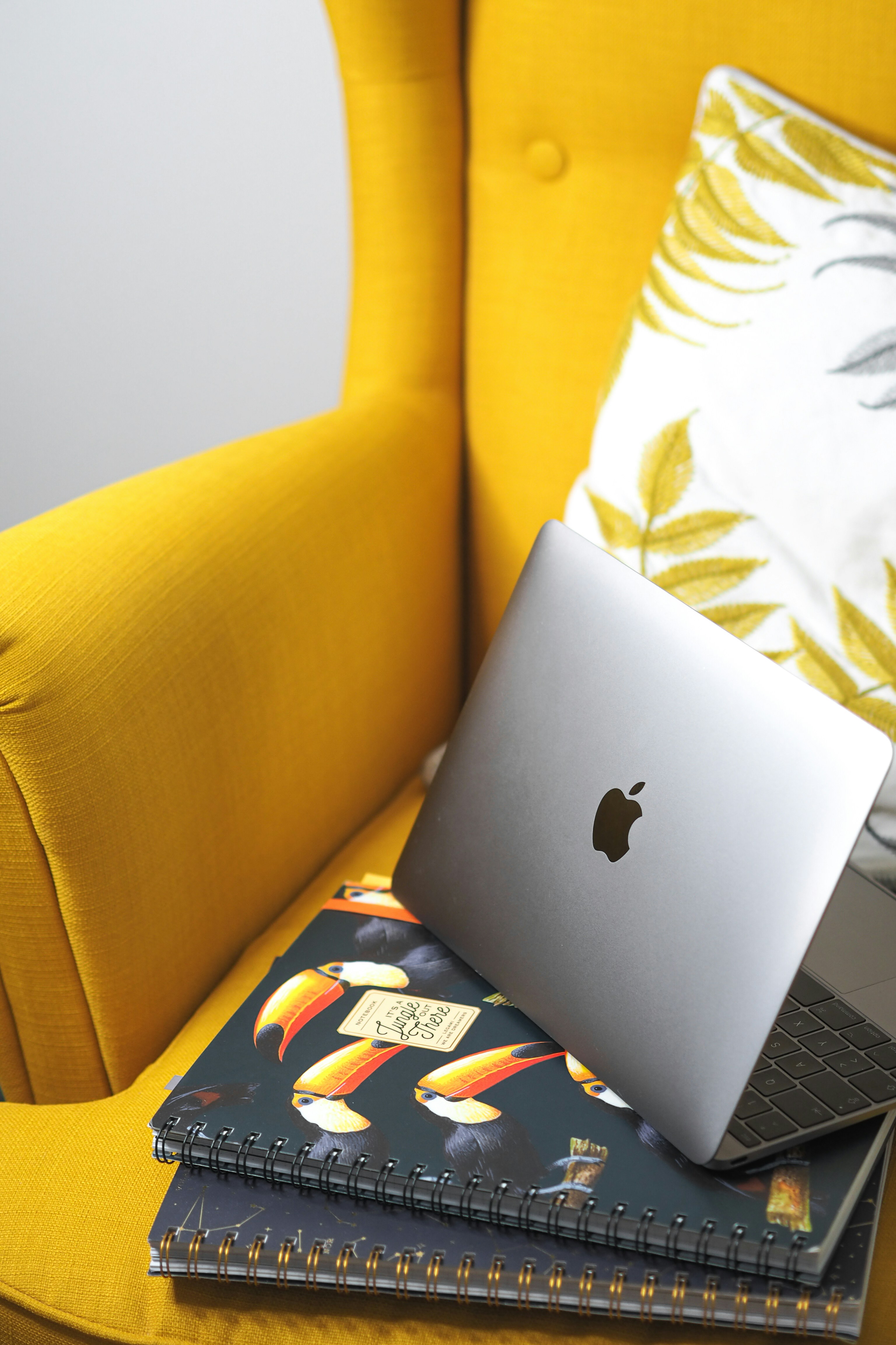 komputer laptop yang duduk di atas kursi kuning