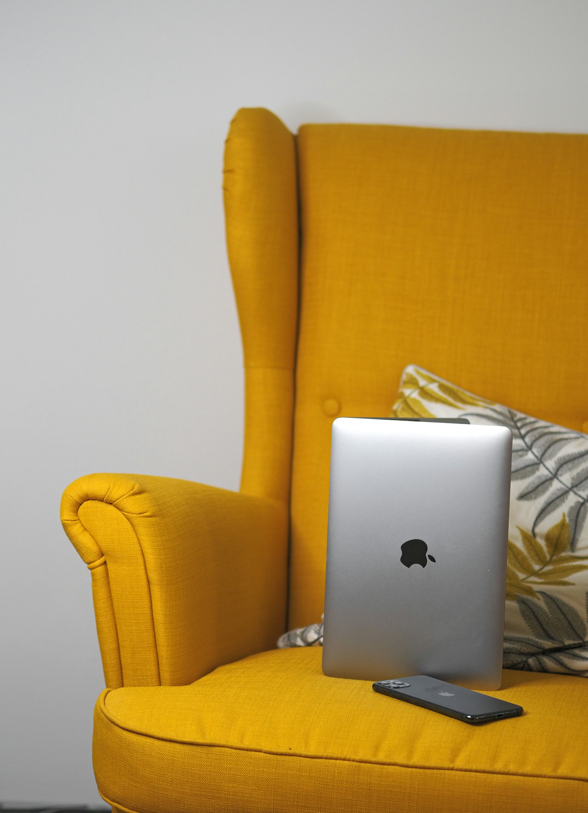 a laptop computer sitting on top of a yellow chair