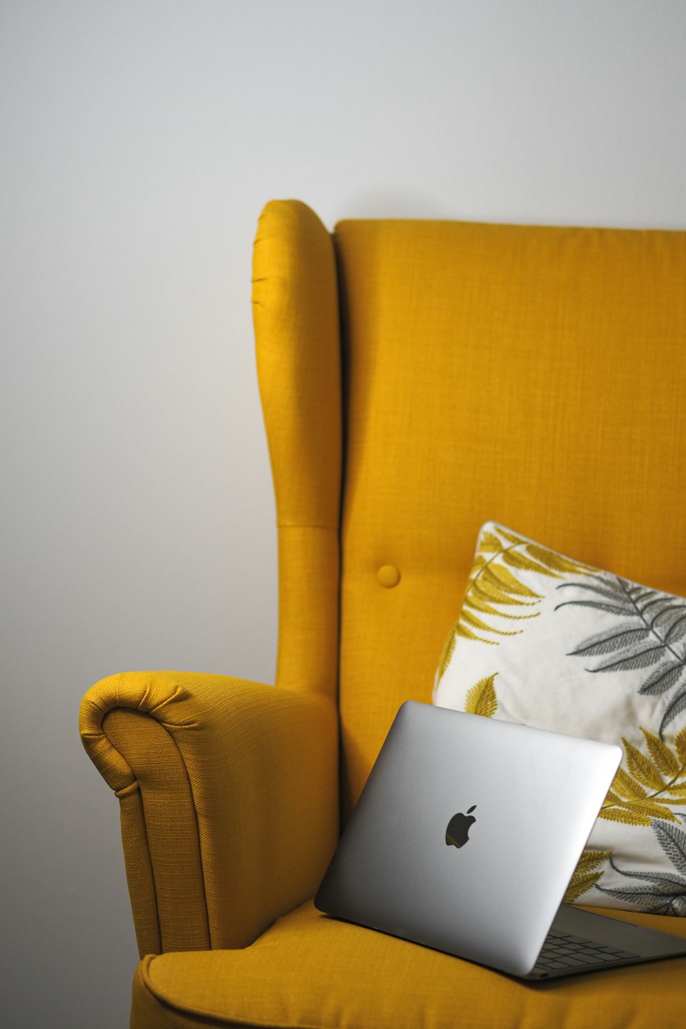 Ein Laptop sitzt auf einem gelben Stuhl