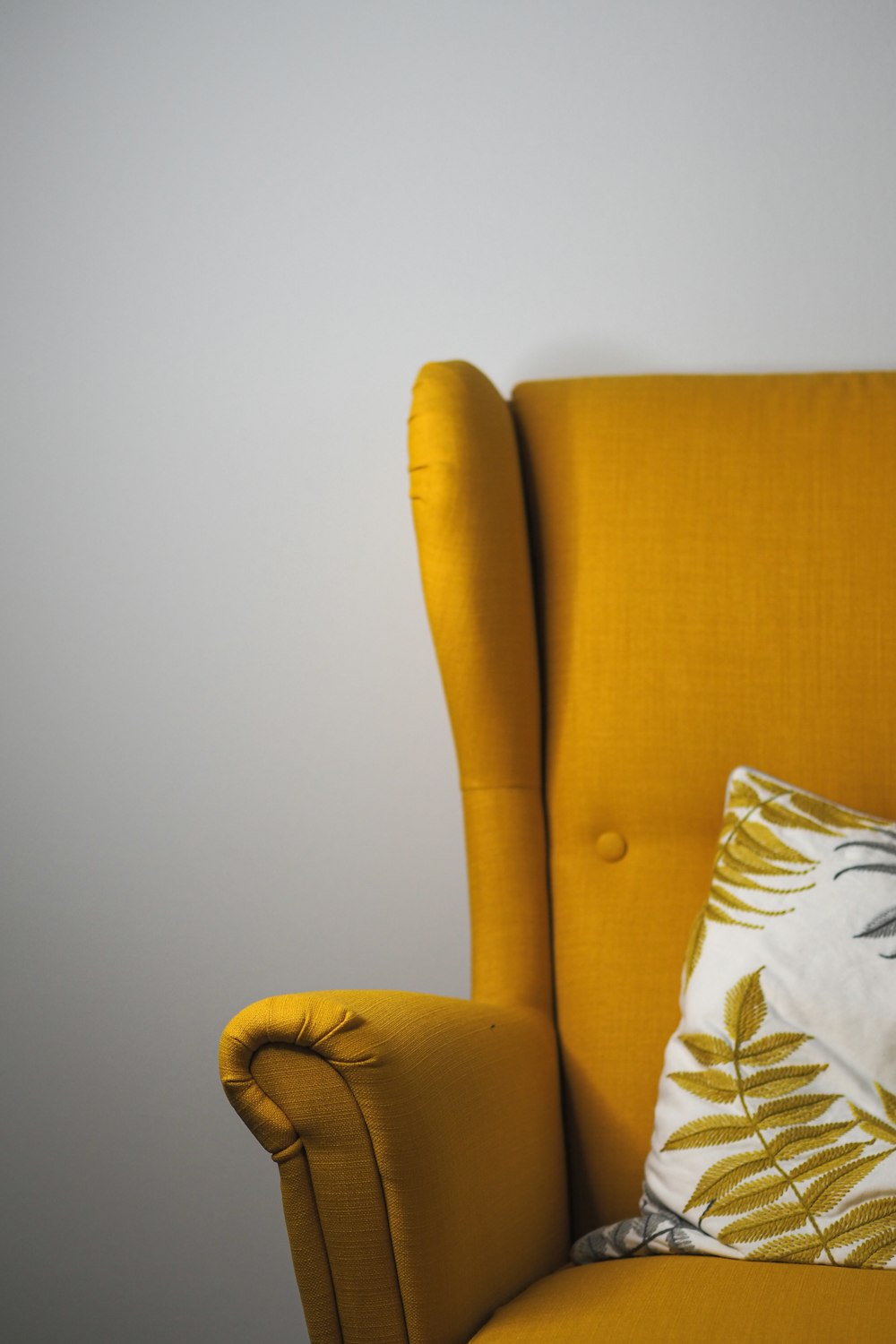 a yellow chair with a pillow on top of it