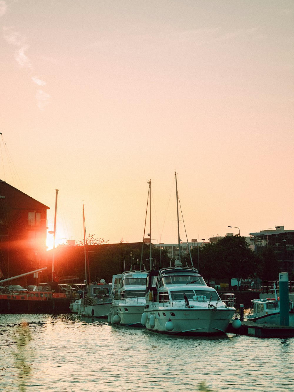 a group of boats sitting in a harbor at sunset